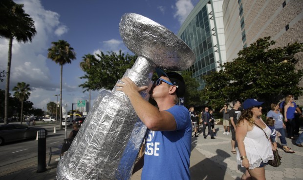 Josh Hogan kisses a replica Stanley Cup he made out of tin foil outside Amalie Arena before the sta...