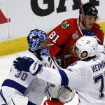 
              Tampa Bay Lightning goalie Ben Bishop (30) and Victor Hedman (77) celebrate as Chicago Blackhawks' Marian Hossa (81) skates past following the Lightning's 3-2 victory in Game 3 of the NHL hockey Stanley Cup Final on Monday, June 8, 2015, in Chicago. (AP Photo/Charles Rex Arbogast)
            