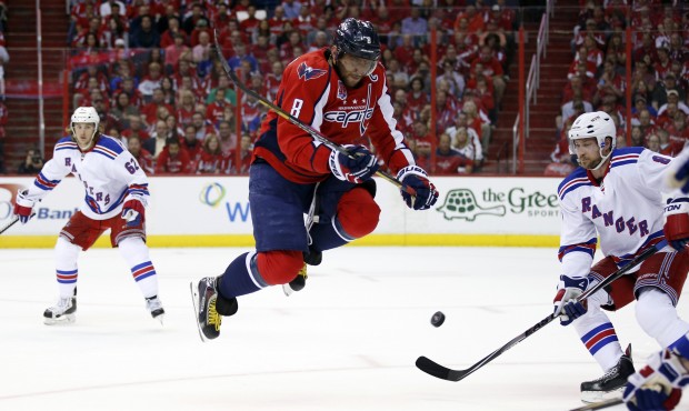 Washington Capitals left wing Alex Ovechkin (8), from Russia, jumps over a teammate’s shot as...