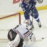 
              Chicago Blackhawks goalie Corey Crawford (50) , bottom, blocks a shot by Tampa Bay Lightning right wing J.T. Brown (23) during the first period in Game 1 of the NHL hockey Stanley Cup Final in Tampa, Fla., Wednesday, June 3, 2015.  (AP Photo/Phelan M. Ebenhack)
            