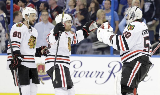 Chicago Blackhawks goalie Corey Crawford (50) is congratulated by center Antoine Vermette (80) and ...