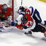 
              Chicago Blackhawks' Kimmo Timonen, front right, and Tampa Bay Lightning's Alex Killorn get tangled up as Blackhawks goalie Corey Crawford, left, watches during the first period in Game 4 of the NHL hockey Stanley Cup Final Wednesday, June 10, 2015, in Chicago. (AP Photo/Charles Rex Arbogast)
            