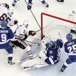 
              Tampa Bay Lightning goalie Ben Bishop (30) blocks a shot by Chicago Blackhawks center Andrew Desjardins (11) as center Tyler Johnson (9) and defenseman Matt Carle (25) help defend during the third period of Game 5 of the NHL hockey Stanley Cup Final, Saturday, June 13, 2015, in Tampa, Fla. The Blackhawks won 2-1. (AP Photo/John Raoux)
            