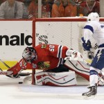 
              Chicago Blackhawks goalie Corey Crawford, left, reaches for a loose puck as Tampa Bay Lightning's J.T. Brown watches during the first period in Game 4 of the NHL hockey Stanley Cup Final on Wednesday, June 10, 2015, in Chicago. (AP Photo/Charles Rex Arbogast)
            