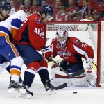  Washington Capitals center Michael Latta (46) blocks New York Islanders left wing Matt Martin (17) away from the puck with goalie Braden Holtby (70) in goal, during the second period of Game 5 in the first round of the NHL hockey Stanley Cup playoffs, Thursday, April 23, 2015, in Washington. (AP Photo/Alex Brandon)
            
