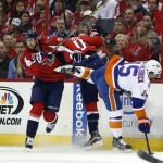 
              Washington Capitals center Brooks Laich (21), right wing Troy Brouwer (20) and New York Islanders right wing Cal Clutterbuck (15) collide during the first period of Game 5 in the first round of the NHL hockey Stanley Cup playoffs, Thursday, April 23, 2015, in Washington. (AP Photo/Alex Brandon)
            