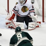 
              Chicago Blackhawks goalie Corey Crawford (50) swats away a shot by Minnesota Wild center Mikko Koivu (9), of Finland, during the first period of Game 4 in the second round of the NHL Stanley Cup hockey playoffs Thursday, May 7, 2015, in St. Paul, Minn. (AP Photo/Ann Heisenfelt)
            