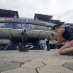 
              Tina Ward takes a picture of a statue of Phil Esposito, co-founder the Tampa Bay Lightning, outside Amalie Arena, Friday, June 5, 2015, in Tampa, Fla. While Sun Belt NHL teams from Phoenix to Miami struggle to maintain revenue and relevance in their communities, the Tampa Bay Lightning are thriving. The franchise’s second trip to the Stanley Cup Final is the highlight of a revival under owner Jeff Vinik as the organization builds a vibrant hockey town in a warm-weather climate. Game 2 is scheduled for Saturday night against the Chicago Blackhawks. (AP Photo/Chris Carlson)
            