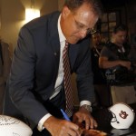 
              Auburn coach Gus Malzahn autographs an item for a fan at the Southeastern Conference NCAA college football media days, Monday, July 13, 2015, in Hoover, Ala. (AP Photo/Butch Dill)
            