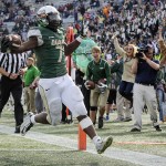 
              File - In this Saturday, Nov. 22, 2014, file photo, UAB running back Jordan Howard (7) scores a touchdown against Marshall during the fourth quarter of an NCAA college football game, in Birmingham, Ala. UAB president Ray Watts is bringing the football program back. He told The Associated Press that he decided on Monday, June 1, 2015 to reverse the earlier decision after meetings with UAB supporters continued through the weekend. He says donors have pledged to make up the estimated $17.2 million deficit over the next five years if football is restored. (AP Photo/John Amis, file)
            