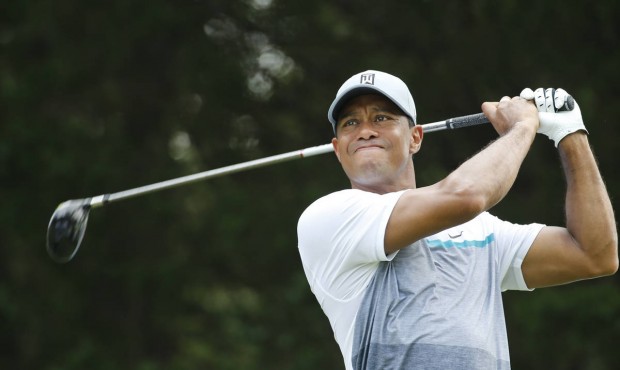 Tiger Woods watches his tee shot on the 18th hole during a practice round for the Quicken Loans Nat...