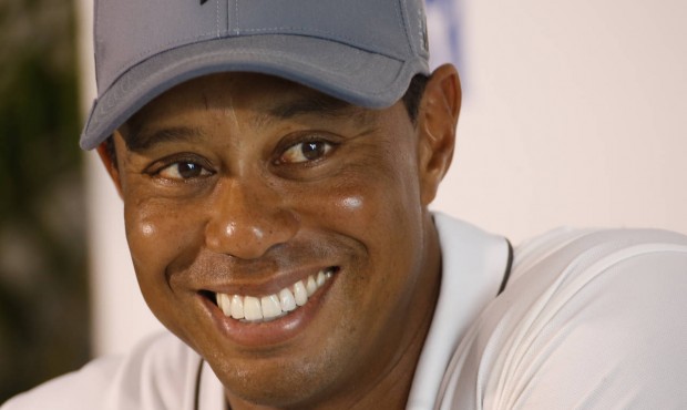 Tiger Woods smiles as he answers a question during a news conference prior to the start of the Quic...