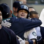 Seattle Mariners' Mike Zunino is embraced in the dugout after his home run against the Arizona Diamondbacks in the third inning of a baseball game, Tuesday, July 28, 2015, in Seattle. (AP Photo/Elaine Thompson)
