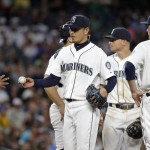 Seattle Mariners manager Lloyd McClendon, left, reaches for the game ball from starting pitcher Hisashi Iwakuma as he pulls Iwakuma against the Arizona Diamondbacks in the sixth inning of a baseball game, Tuesday, July 28, 2015, in Seattle. (AP Photo/Elaine Thompson)
