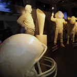               A butter sculpture depicting Ohio State NCAA football coach Urban Meyer, left, and Ohio State Buckeyes mascot Brutus, second from right, are displayed in the dairy building at the Ohio State fairgrounds, Tuesday, July 28, 2015, in Columbus, Ohio. The life-size sculptures are joining the traditional butter cow and calf in a 46-degree cooler in the American Dairy Association display. Also displayed are an Ohio State football helmet and national championship trophy. (Kyle Robertson/The Columbus Dispatch via AP)
            