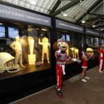               Ohio State Buckeyes mascot Brutus claps his hands after the unveiling of the Ohio State fair butter cow and Ohio State football display in the dairy building at the Ohio State fairgrounds, Tuesday, July 28, 2015, in Columbus, Ohio. Ohio State football sculptures are joining the traditional butter cow and calf in a 46-degree cooler in the American Dairy Association display. Also displayed is a butter sculpture depicting Ohio State NCAA football coach Urban Meyer, second from left in back. (Kyle Robertson/The Columbus Dispatch via AP)
            